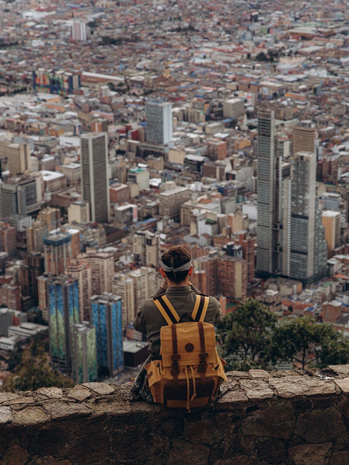 Viajero solo con mochila observando una ciudad